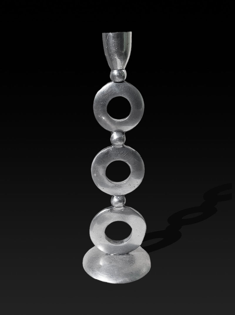A sleek metal sculpture stands against a black background, showcasing a series of three stacked rings supported by small connecting spheres. The elegant silver plating and smooth, minimalist design add a modern, artistic flair, reminiscent of the vintage Totem Candle Holder by Les Objoies.