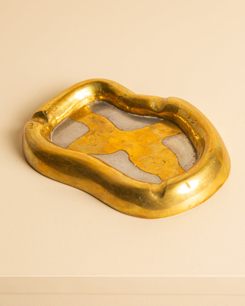 Golden brass brutalist ashtray with sculptural cross-shaped design