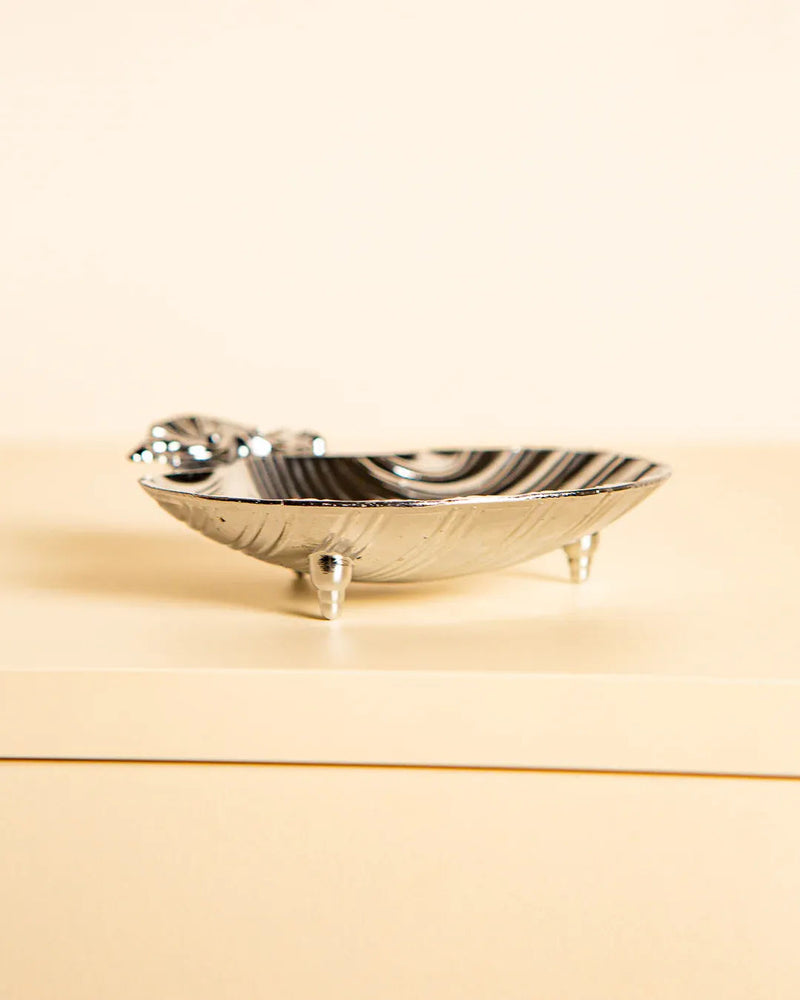 The Treaptyque Shell Shaped Italian Vide-poches 80's is a small, silver metal dish with four short legs and a decorative faucet, styled like a vintage clawfoot bathtub and set on a beige surface against a neutral background.