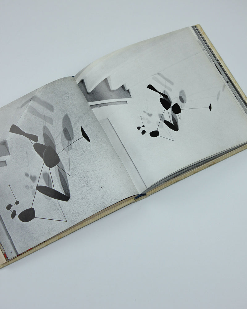 Open Calder art book showing abstract mobile sculptures in black and white