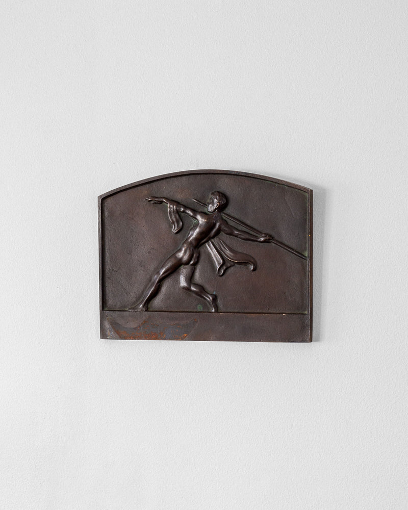 The Spigel Art Deco Bronze Wall Relief features a classic image of an athlete about to throw a javelin, highlighting the dynamic stance and flowing garment against a plain background, making it an elegant addition to any wall plaque collection.