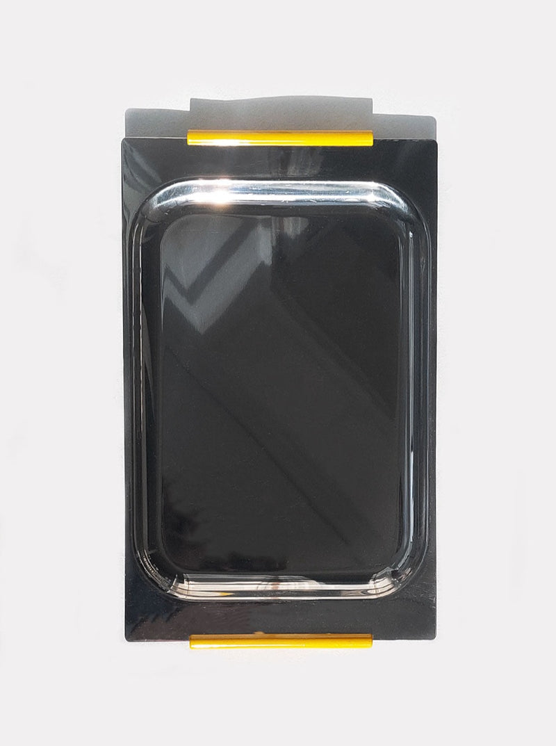 A square black Les Objoies steel rectangular minimalist tray with a metallic finish, outlined by a gray casing featuring yellow stripes at the top and bottom, perfect for organizing desk essentials.