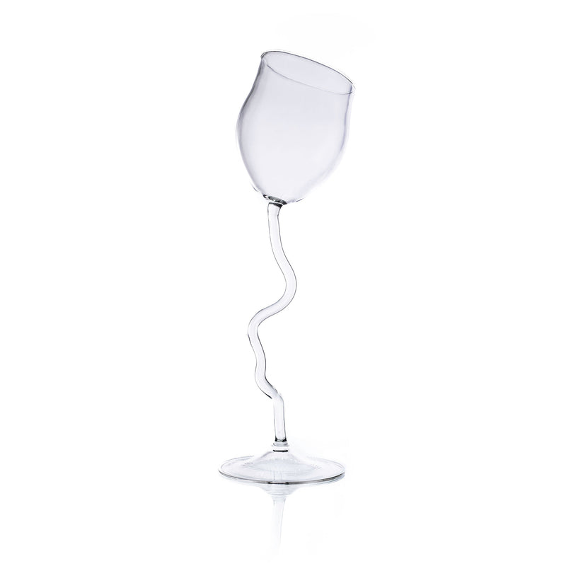 The Long Wine Glass by Agustina Ros is a clear, handcrafted piece with a wavy stem, standing upright against a white background. Its surrealist design gives this unique wine glass a whimsical and creative look.