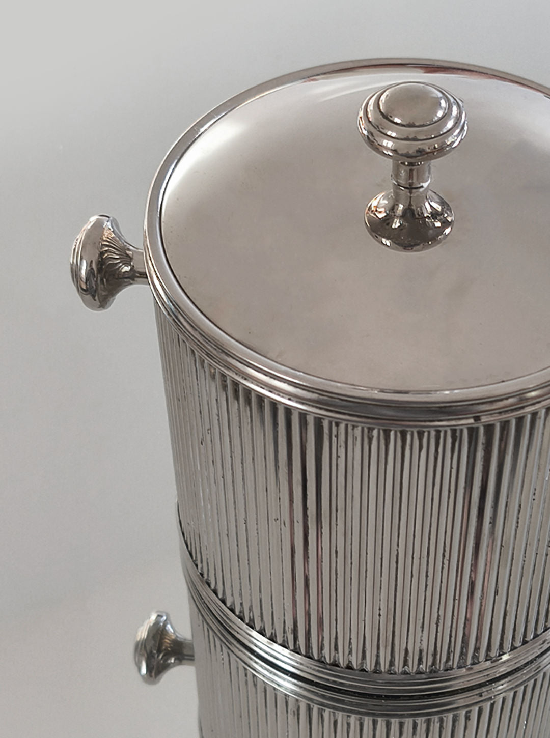 Silver plated ice bucket with ribbed texture and ornate lid detail
