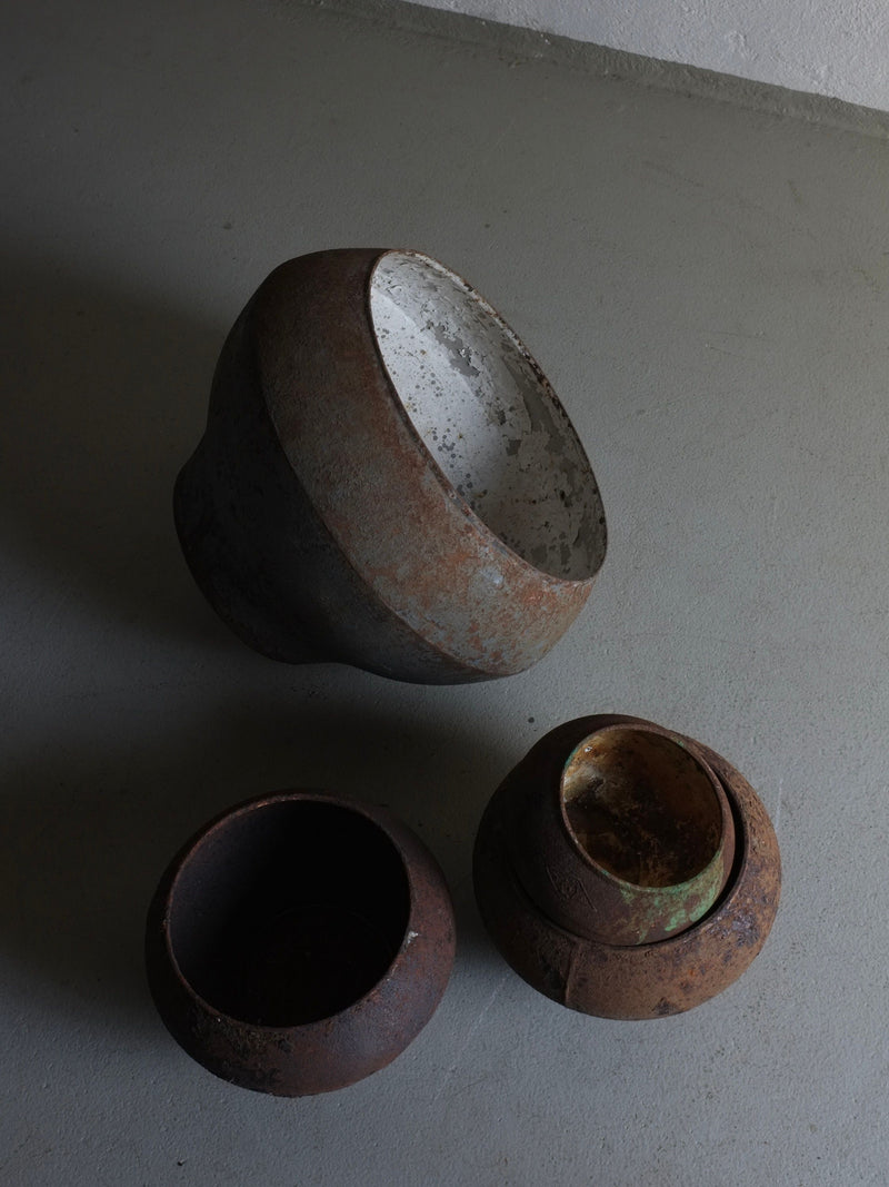 Rustic iron cooking pots showing weathered interiors and patina