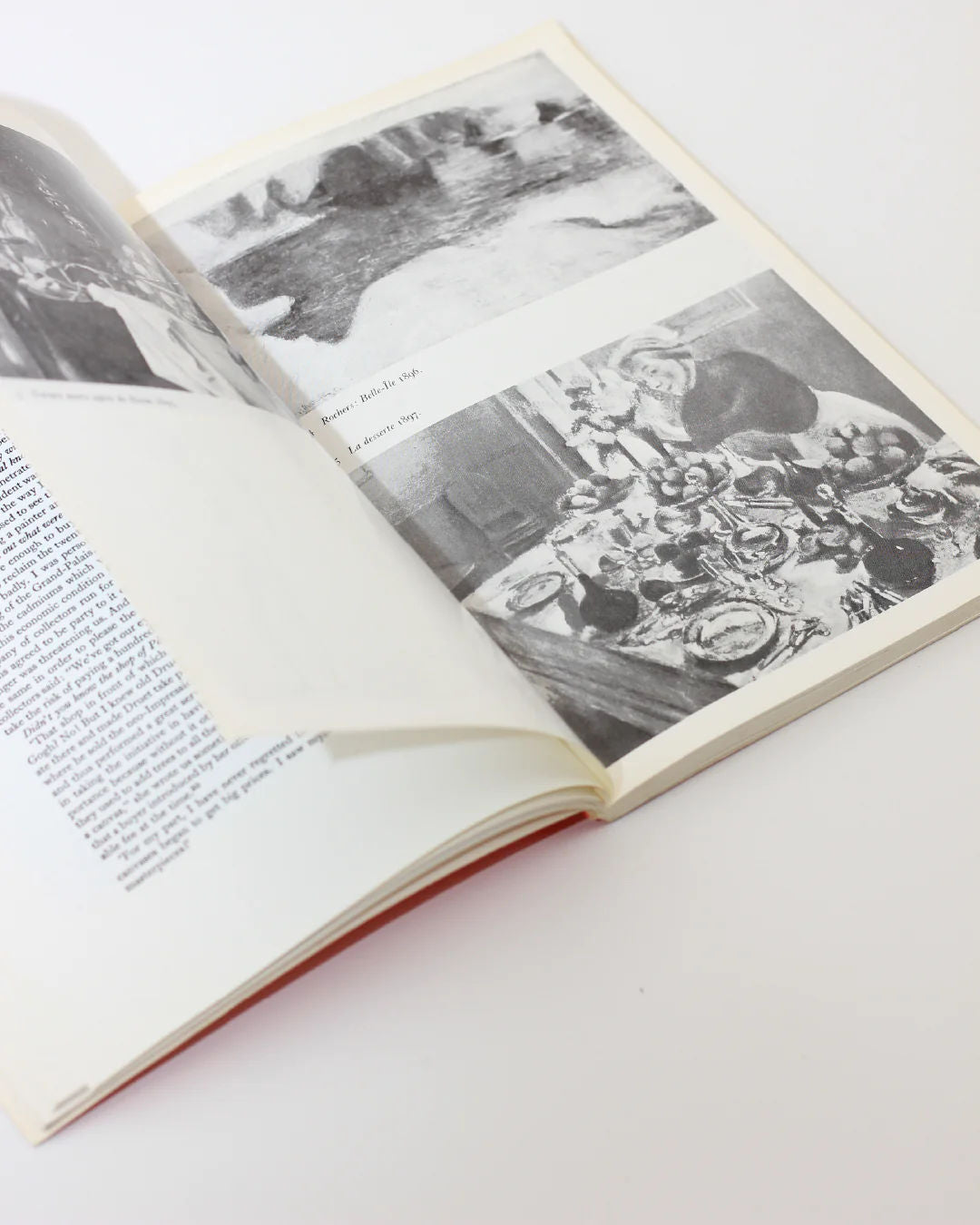 The Matisse on Art Book by Boga Avante Shop lies open on a white surface, displaying modern art-like black and white images on the right page with text on the left. A partially turned page hides some text, inviting artistic contemplation.