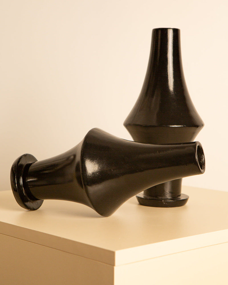 Black ceramic vases arranged on display showing conical forms