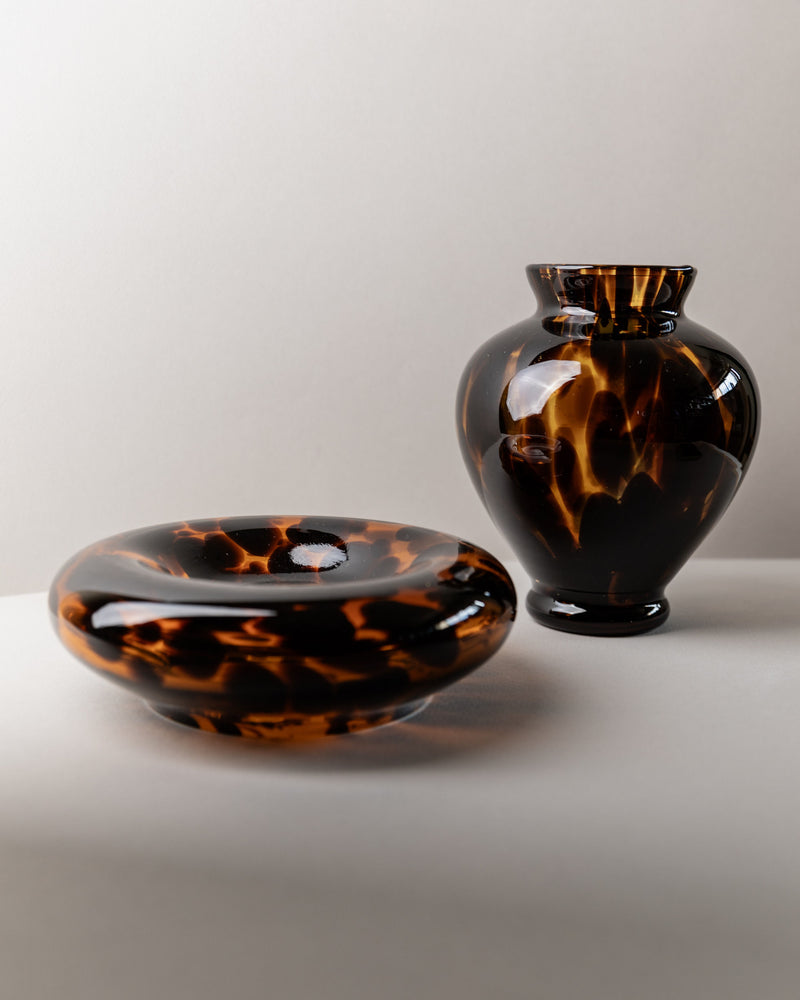 A Set of Murano Glass Vase and Bowl - Tortoise by Bottega Jacobs, Italy 80s, features a glossy, optic pattern: one wide and shallow bowl and one tall, narrow-necked vase, both reflecting light in classic Italian glass art style.