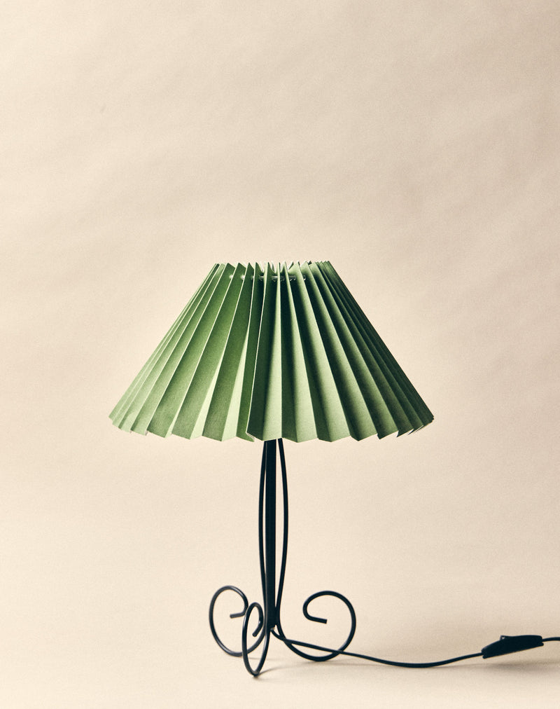 Pise table lamp with pleated green shade and curved black metal base