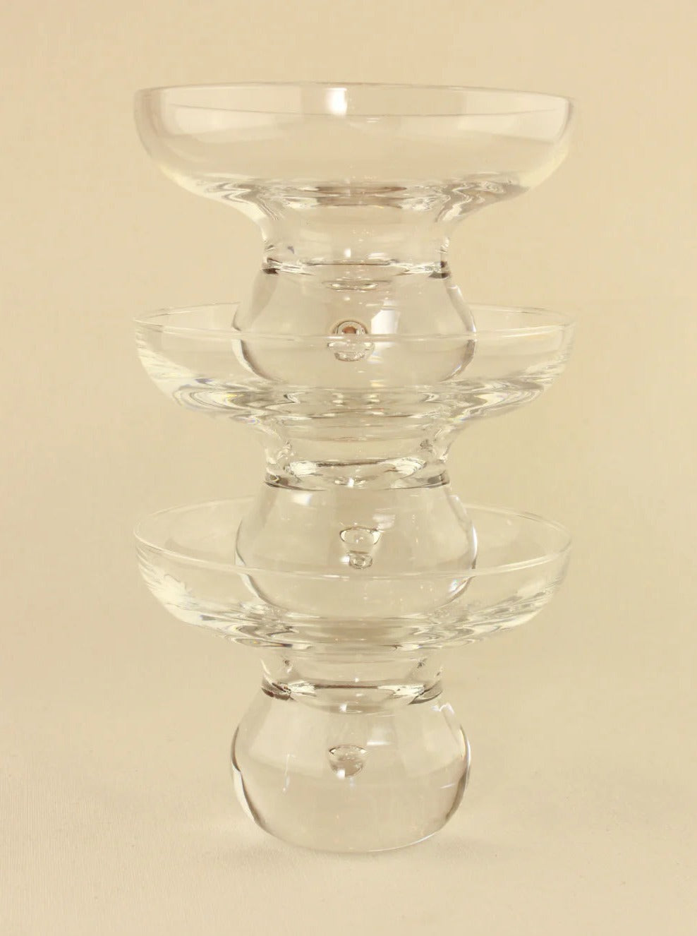 Three handcrafted Italian Glasses from Boga Avante Shop are stacked vertically, each smaller than the one below it. The glasses have wide, shallow openings and narrow, rounded bases, forming an elegant, symmetrical tower-like structure against a neutral background.