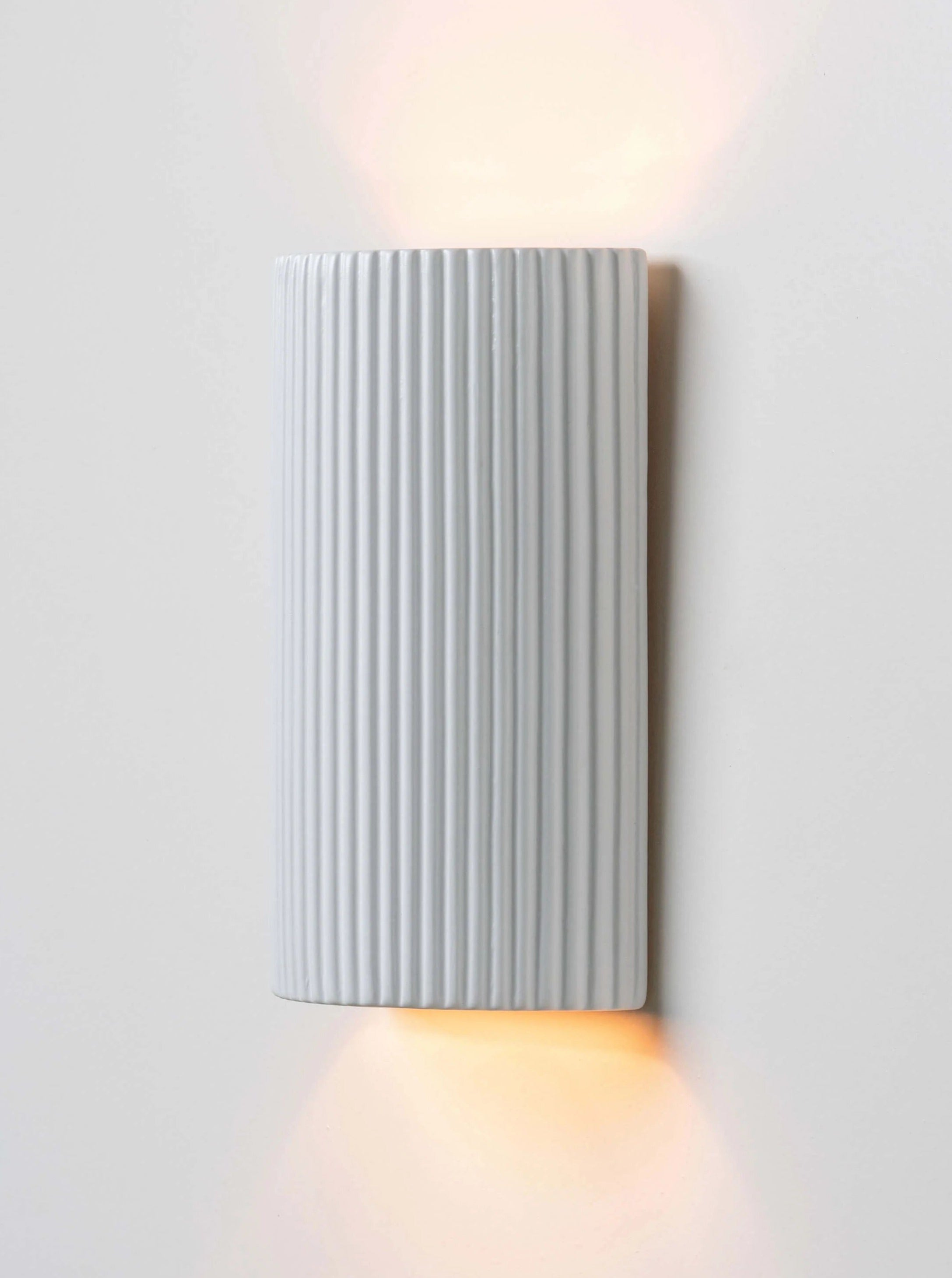 White ribbed ceramic pillar wall light with modern design and soft illumination