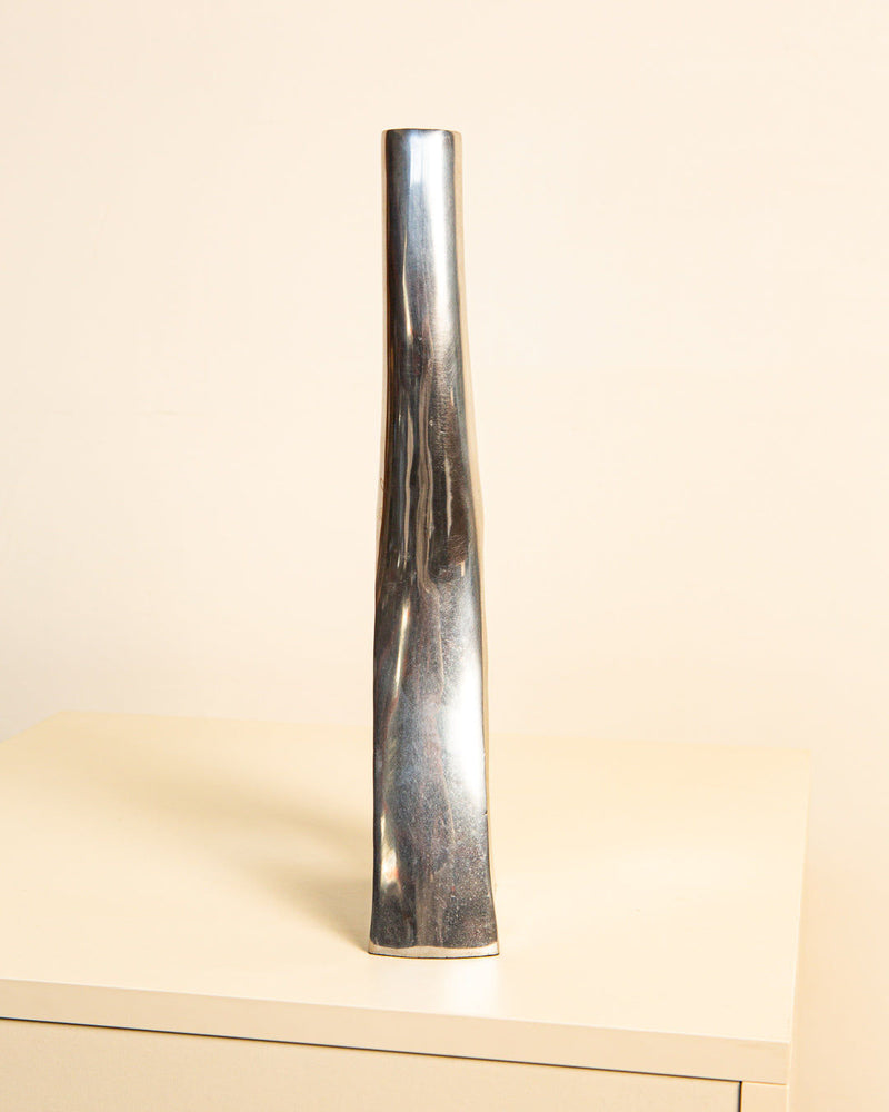 The Italian Vase, Aluminum 80's by Treaptyque is a tall, sleek vase with a tapered design and sculptural presence. It stands on a light surface against a neutral background, enhanced by its cast aluminum finish.