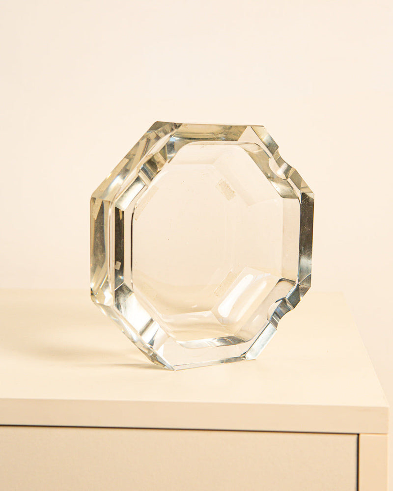 The Treaptyque Octagonal Glass Ashtray from the '80s sits upright on a white surface against a light background, showcasing vintage elegance with its clear, faceted glass design.