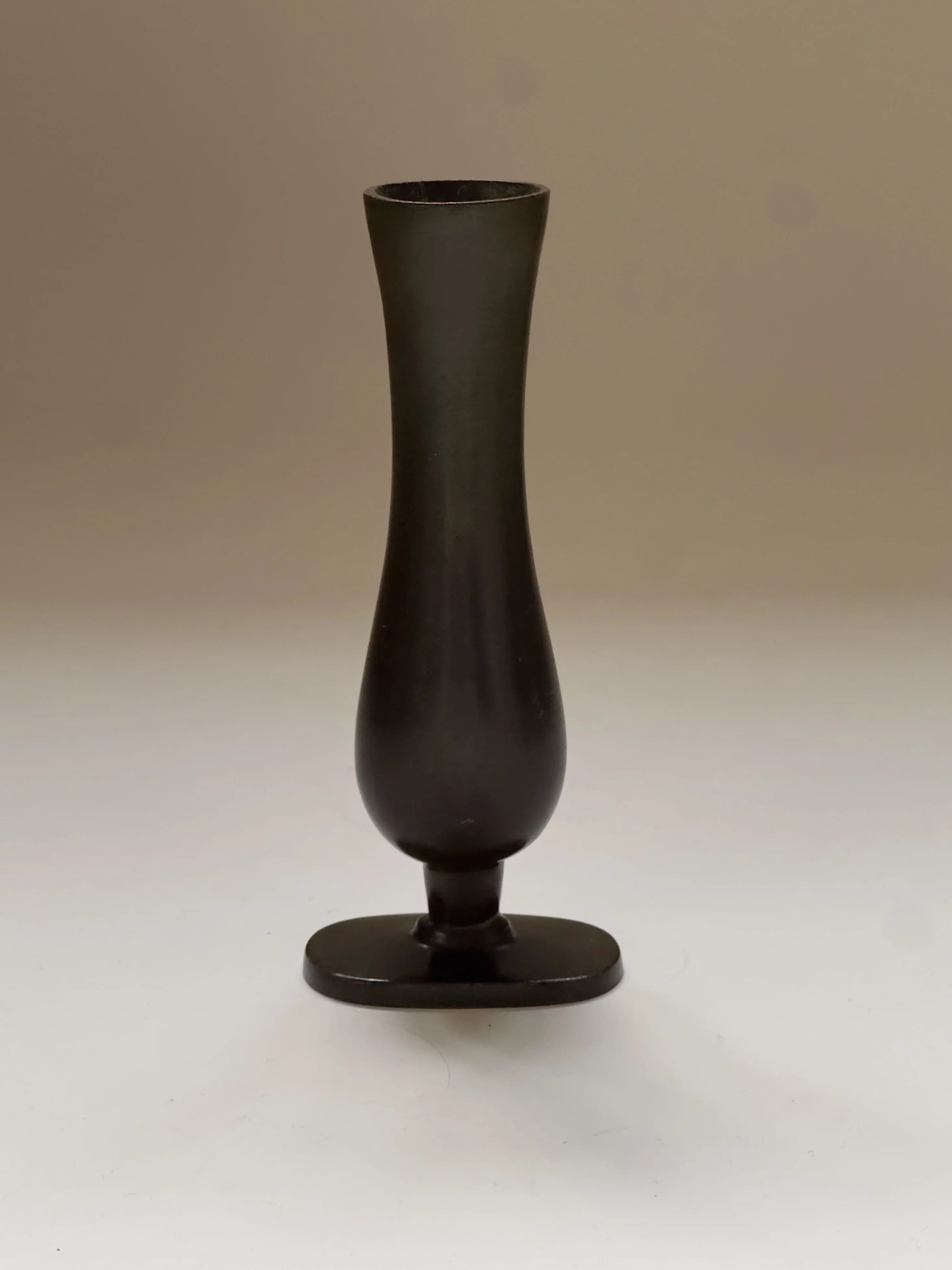 The GAB Bronze vase by Galerie Storm, tall and slender with a bulbous base and narrow top, reminiscent of Swedish Grace, stands on a flat surface against a plain background.