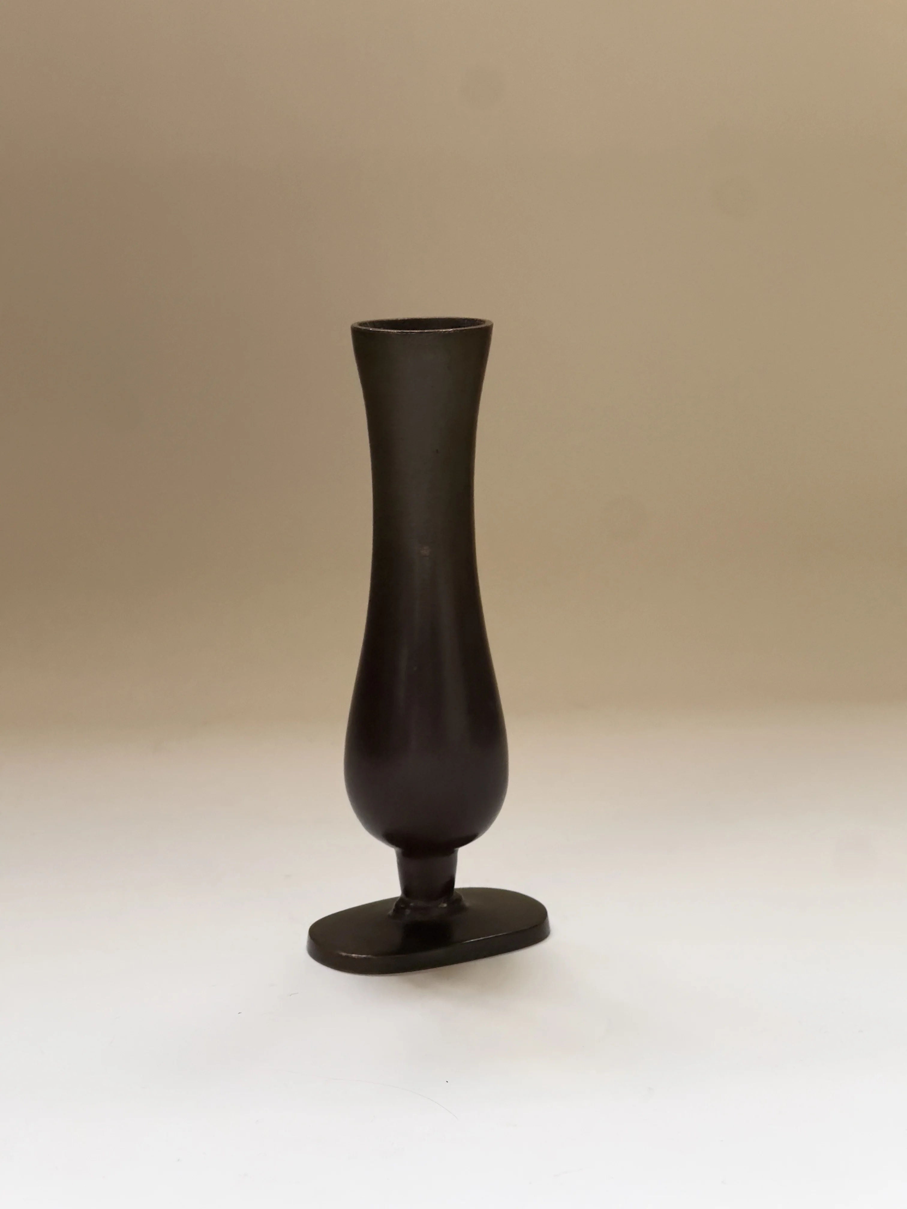 The GAB Bronze vase by Galerie Storm is a tall, slender black vase with a wide base and narrow neck, elegantly reflecting the Art Déco style with hints of Swedish Grace against a neutral background.