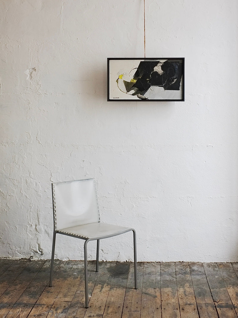 A simple white chair with a metal frame is placed on a worn wooden floor beneath the Abstract Oil Painting by Hans Osswald, Sweden 1950s, from Veter Vintage, displayed on a textured white wall.