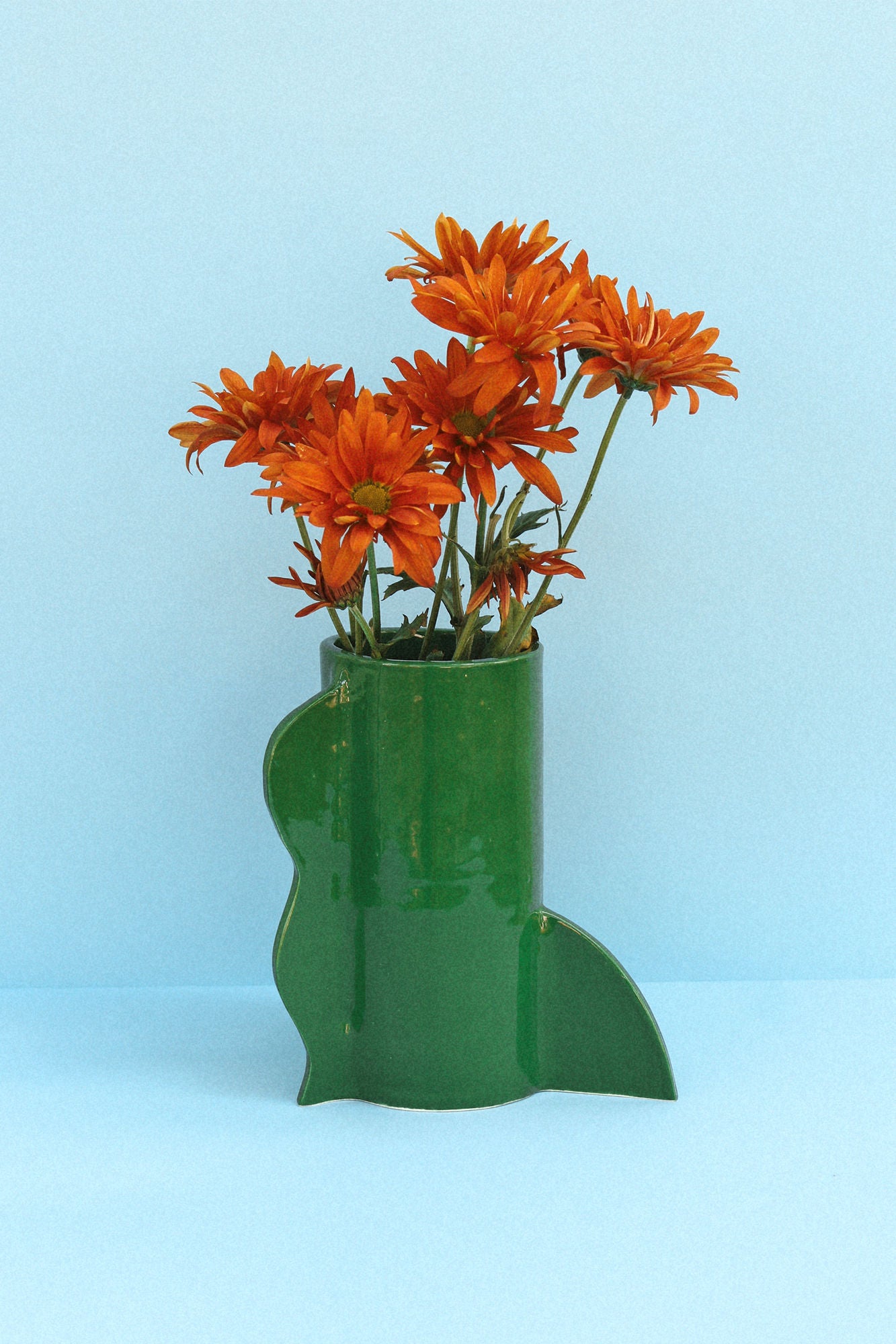 Theatre Vase 04 (Bosque) standing on a wooden table with flowers in it