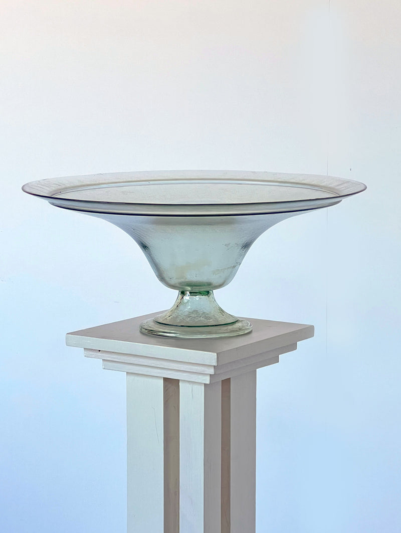 Wide glass compote bowl on marble pedestal, translucent green tint
