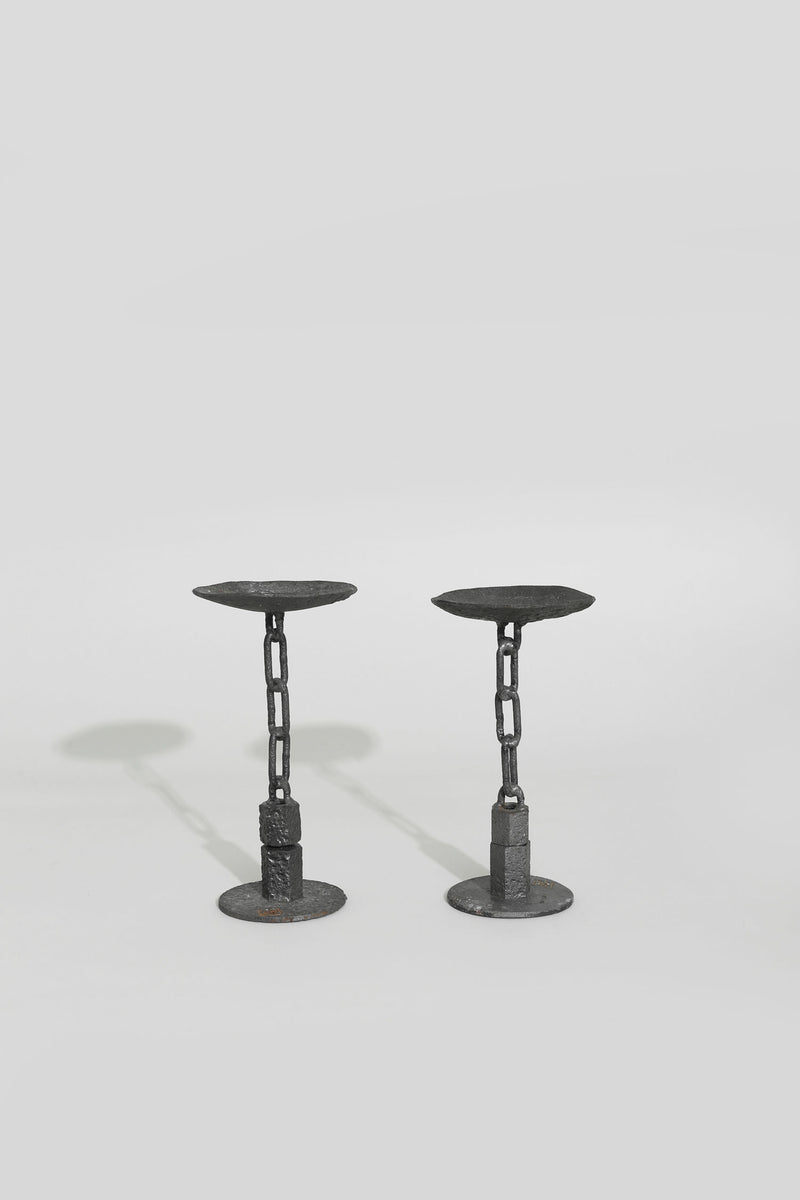 Two black metal chain candlesticks with circular bases and tops