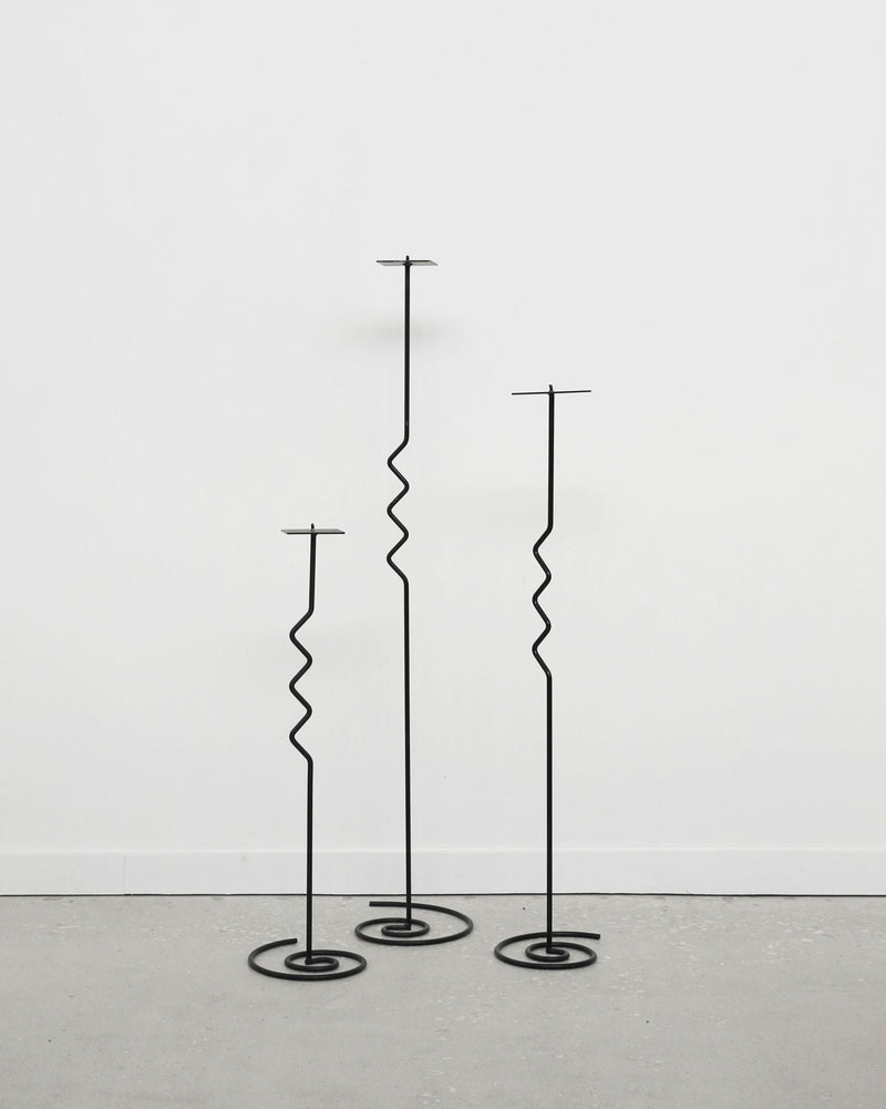 Three black metal spiral floor candleholders of varying heights