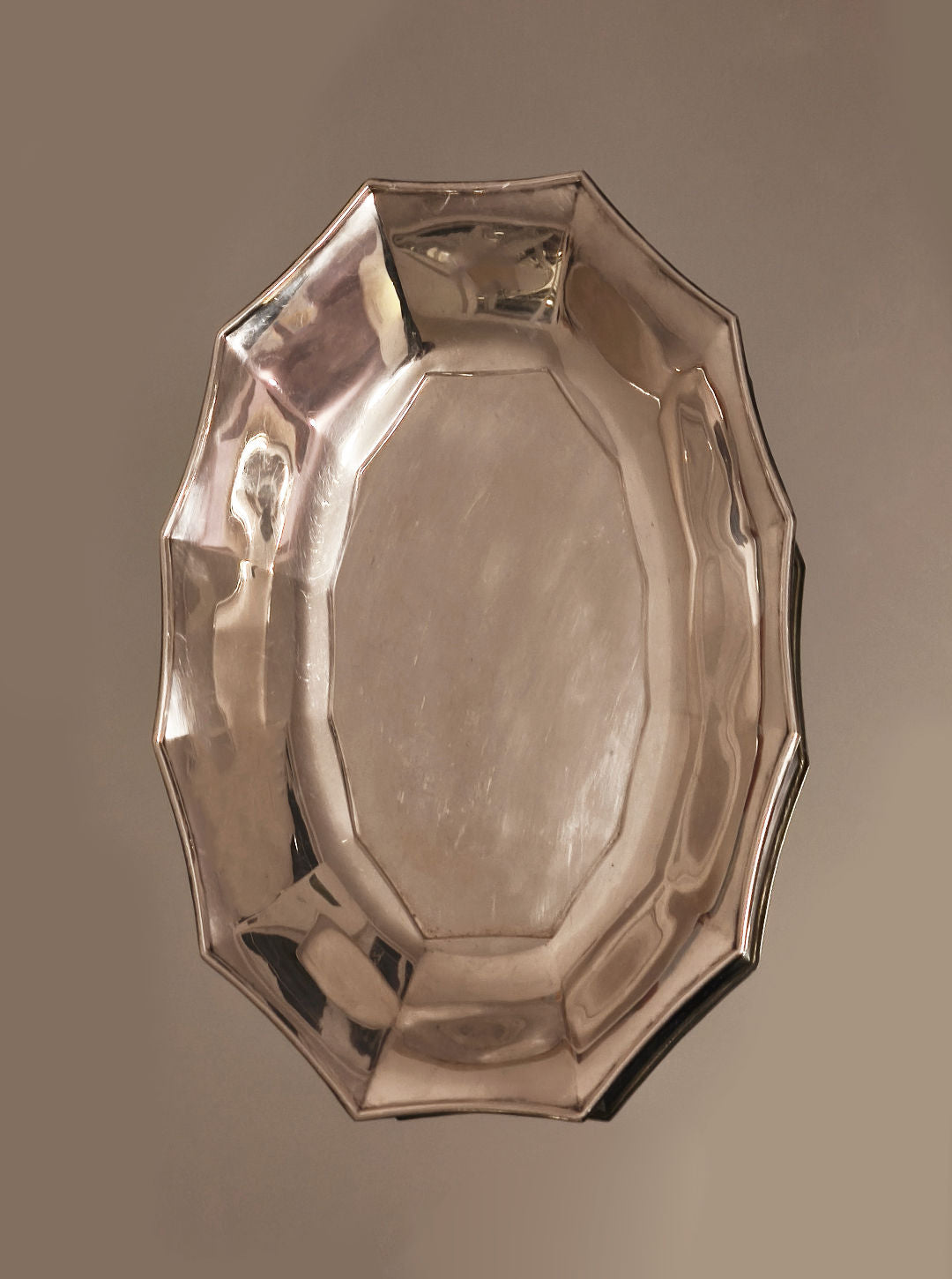 Les Objoies' Silver-plated Tray, featuring an octagonal shape with slightly raised angular edges, rests elegantly against a neutral background exuding sophistication and elegance.