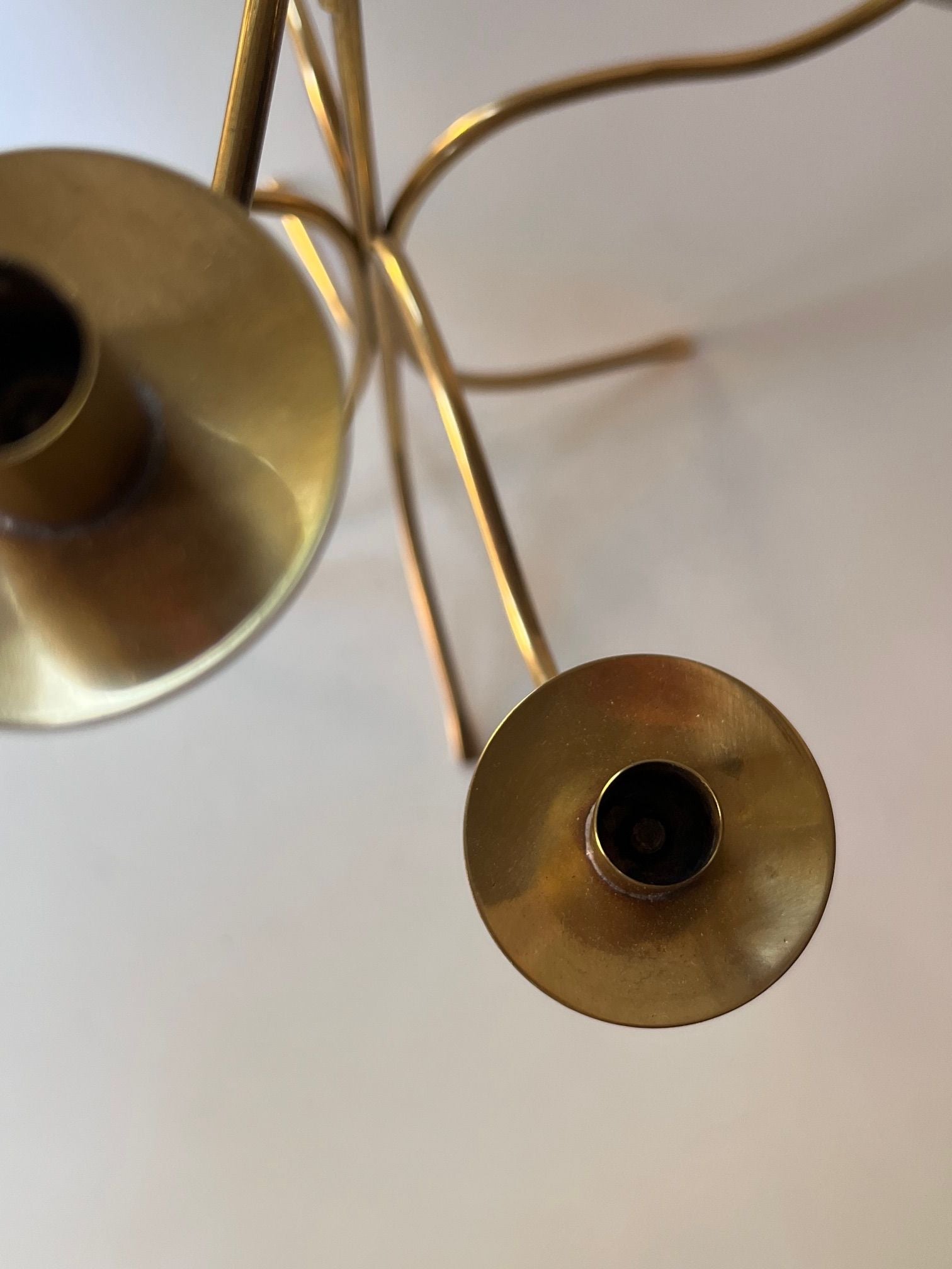 Close-up of a Josef Frank Candle Holder by Médecine with two visible candle holders. The perspective is from above, focusing on the top edges and openings of the holders. The candle holder's arms are gently curved, and the background is out of focus, creating a minimalistic look reminiscent of Svenskt Tenn's designs.