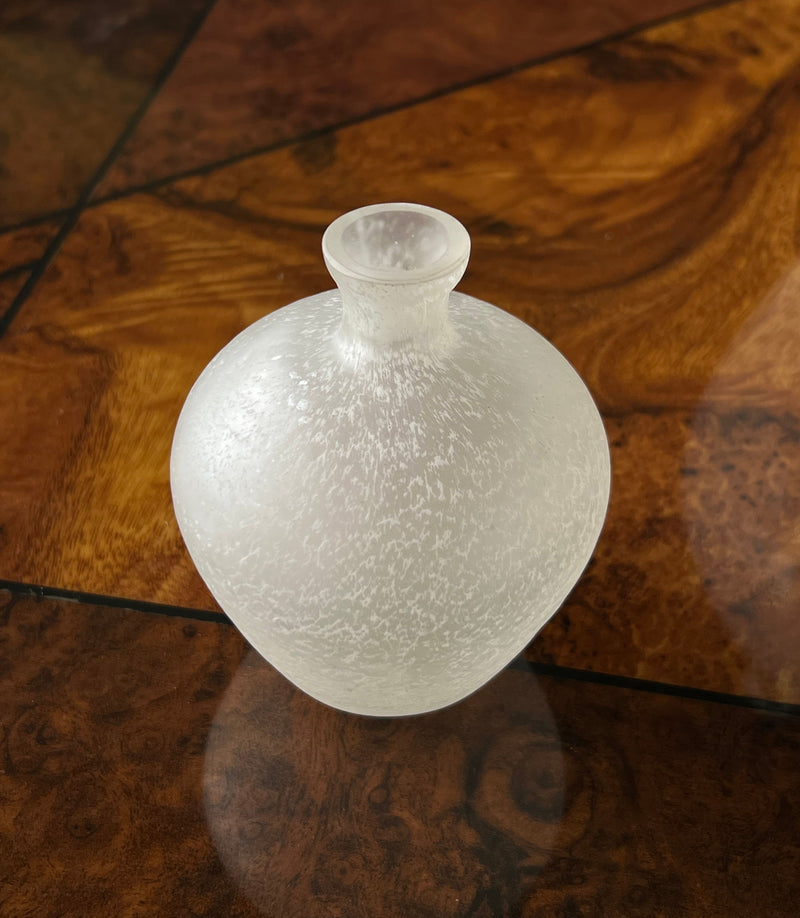 Frosted glass vase with textured surface on wood floor detail