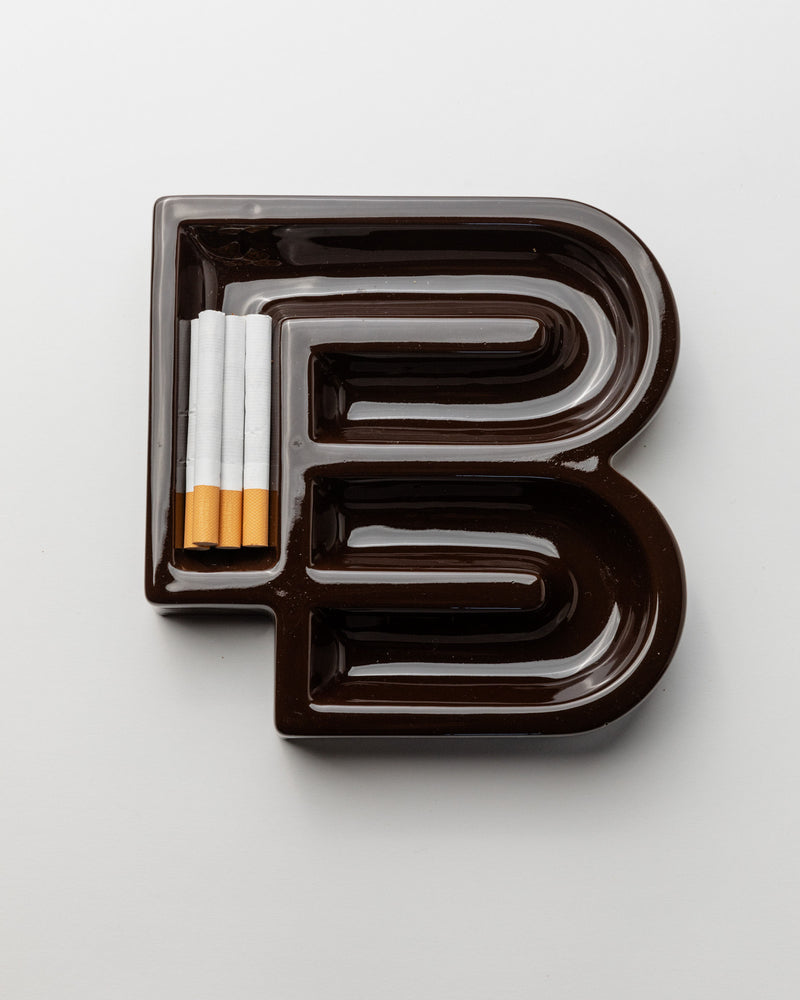 Brown ceramic ashtray detail showing cigarette compartments, Italy 1960s
