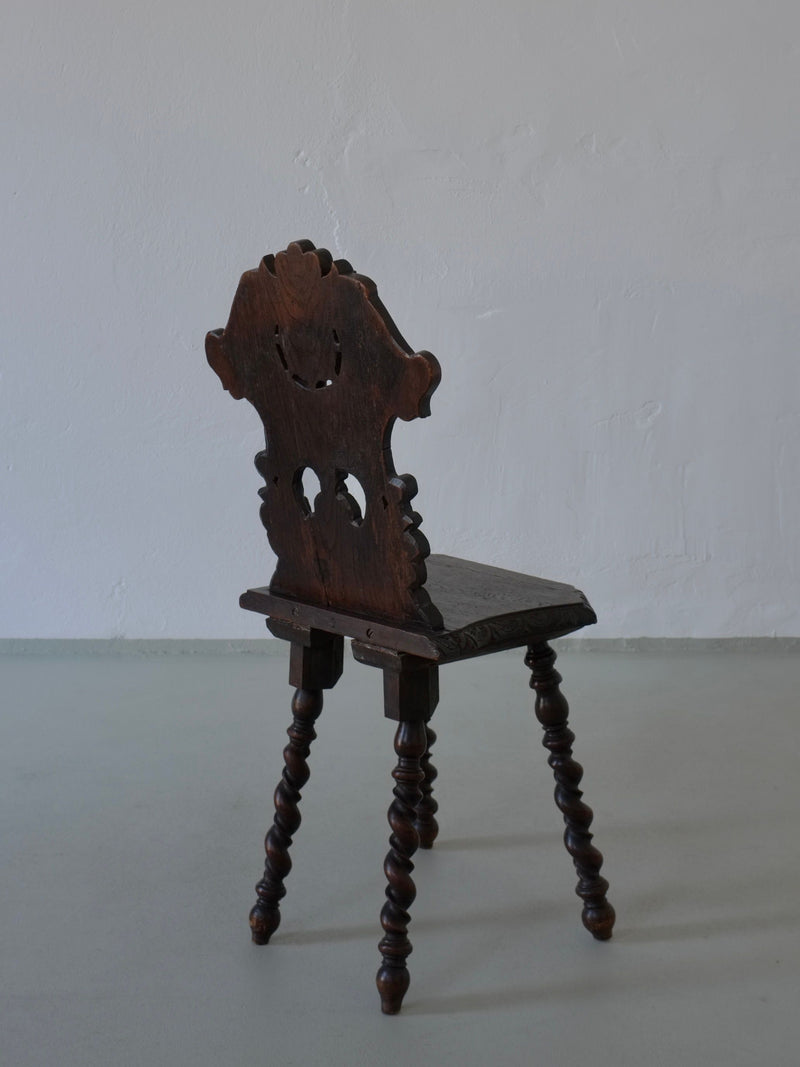 Hand-carved dark oak chair back detail showing ornate 1900s craftsmanship