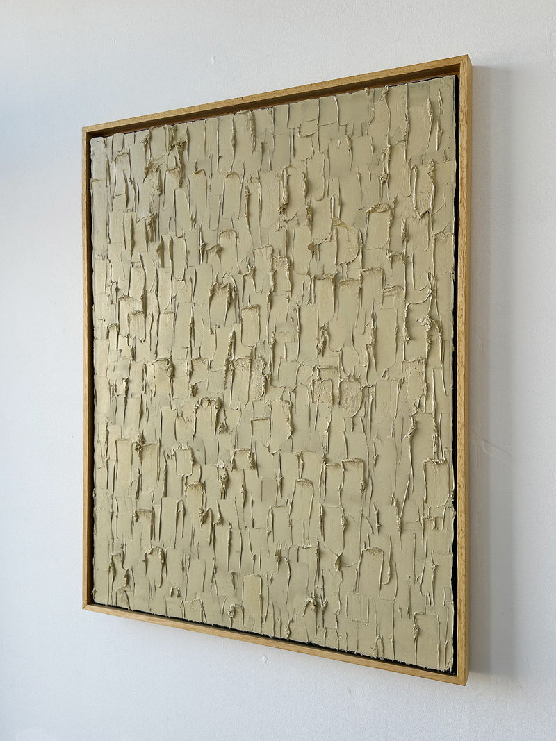 'Buff Titanium' - Heavy Texture by Roi Elmaliah is a framed abstract oil on canvas featuring a beige, textured surface with uneven raised patches and ridges, displayed against a white wall.