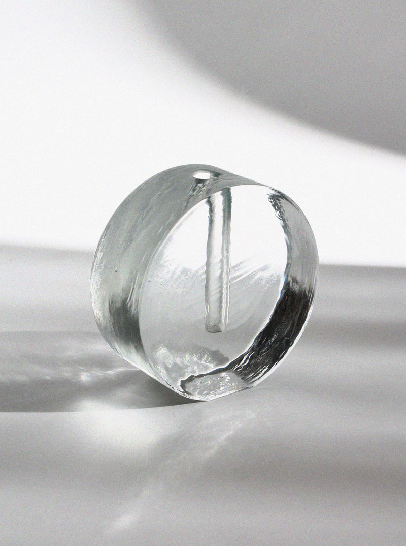Clear glass round block vase with central opening for single stem