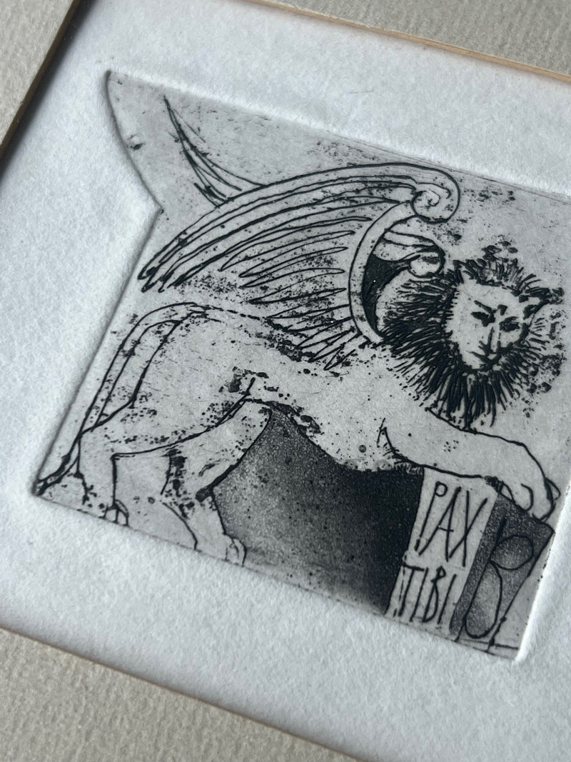 A framed and mounted product by Porter Studio featuring an oak-framed black and white etching of a winged lion with a mane, surrounded by a textured mat. The right side displays a Latin hand illustration with the text "PAX TIBI.