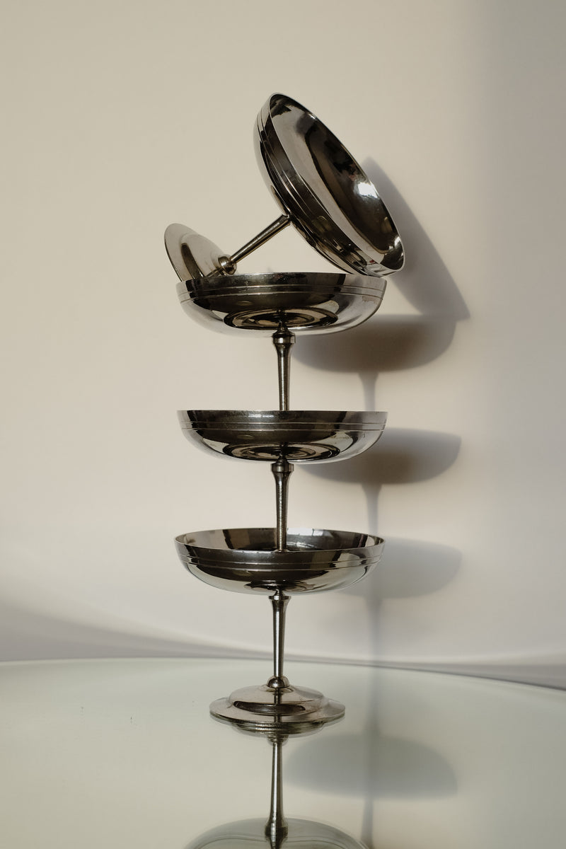 A set of four Ice Coupes by septembre studios, made in France, is arranged vertically on a reflective glass surface, casting shadows on a light-colored wall. The varying sizes create an elegant and modern display, perfect for serving ice cream with style.