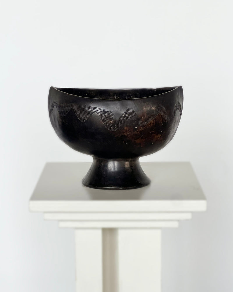 Black ebony carved bowl with geometric patterns on pedestal base