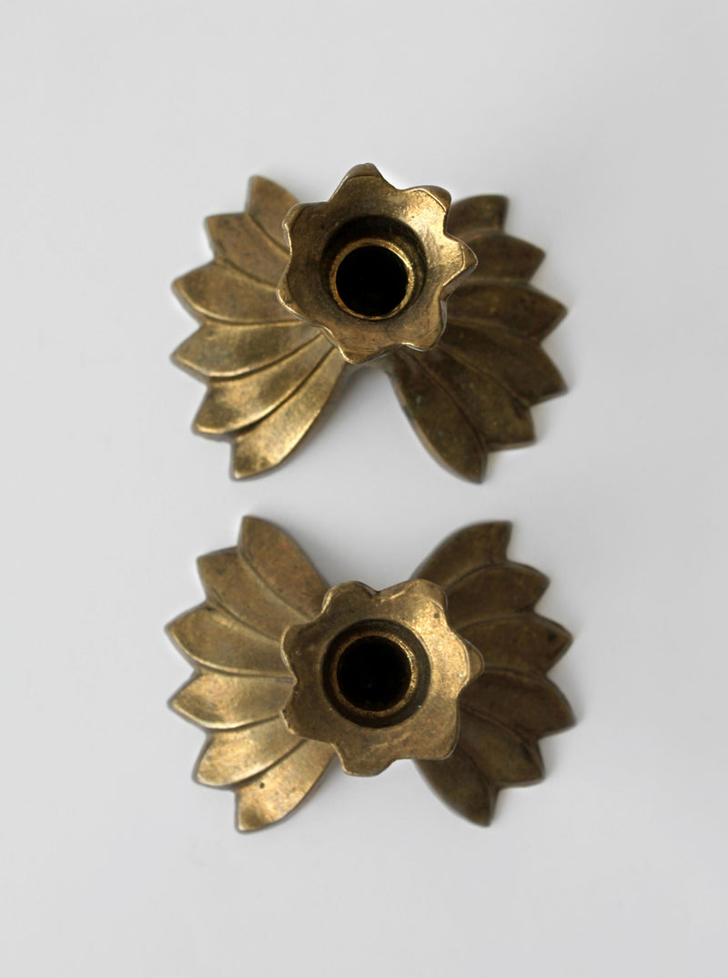 Brass candle holders showing fluted petal design and center wells