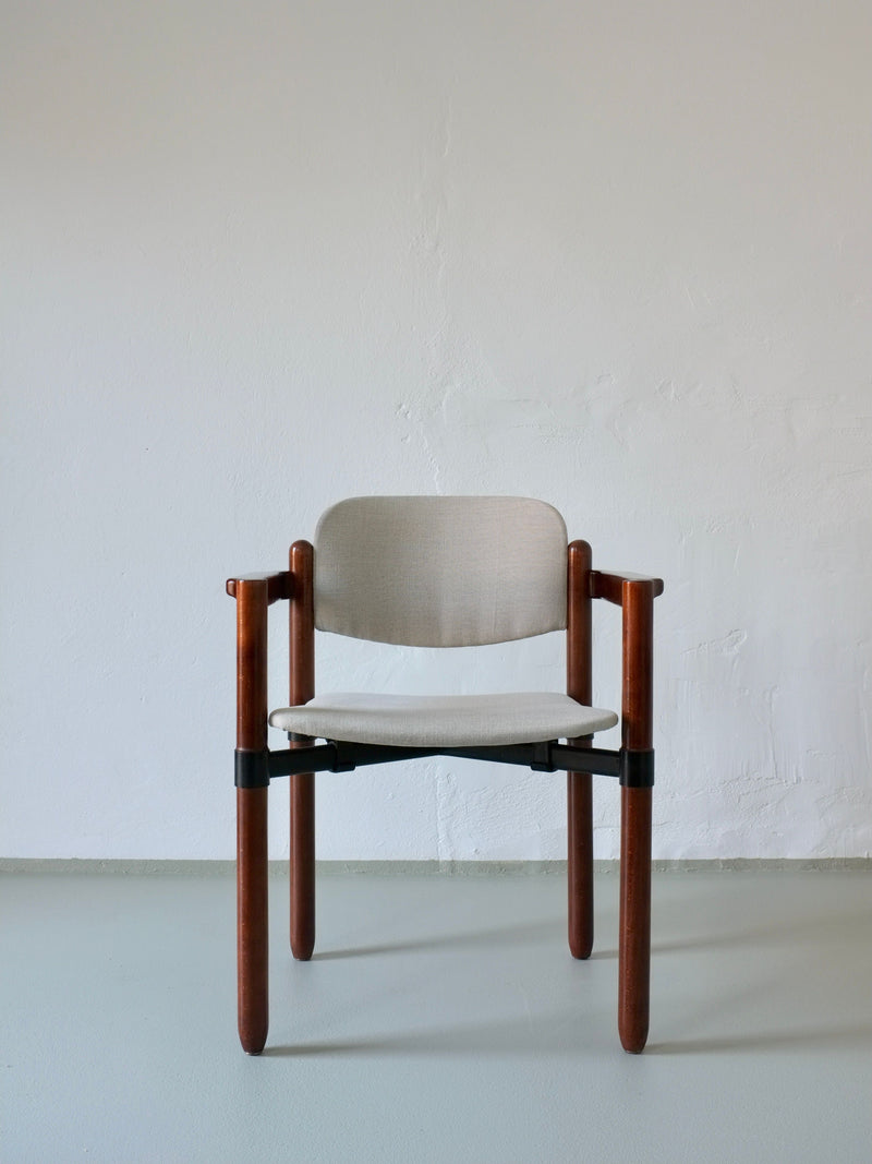 A Veter Vintage Fröscher Sitform armchair from the 1970s stands against a white wall, featuring a modern wooden frame and beige cushioned seat and back, echoing minimalist design with clean lines and iconic styling.