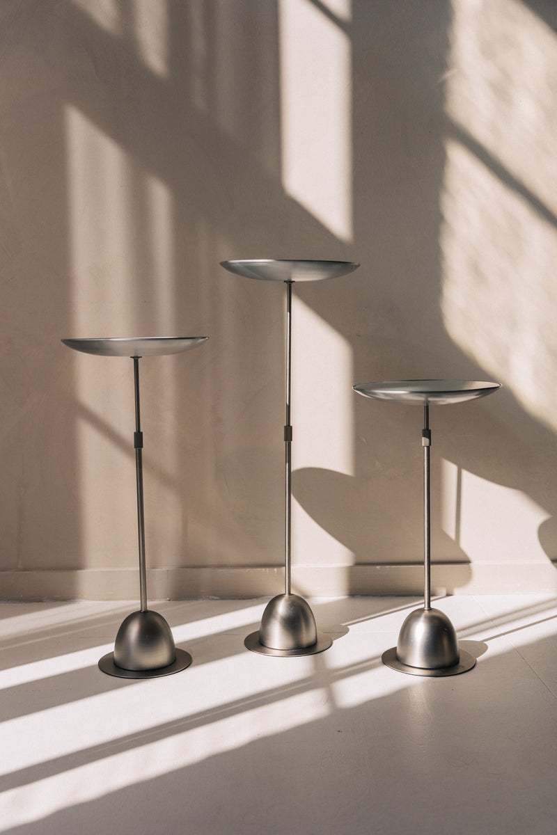 Three postmodern adjustable side tables in brushed metal finish