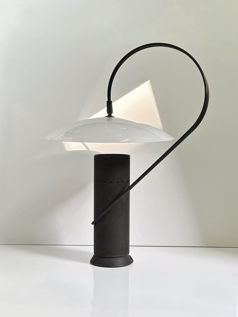Cast iron table lamp with curved arm and white shade detail