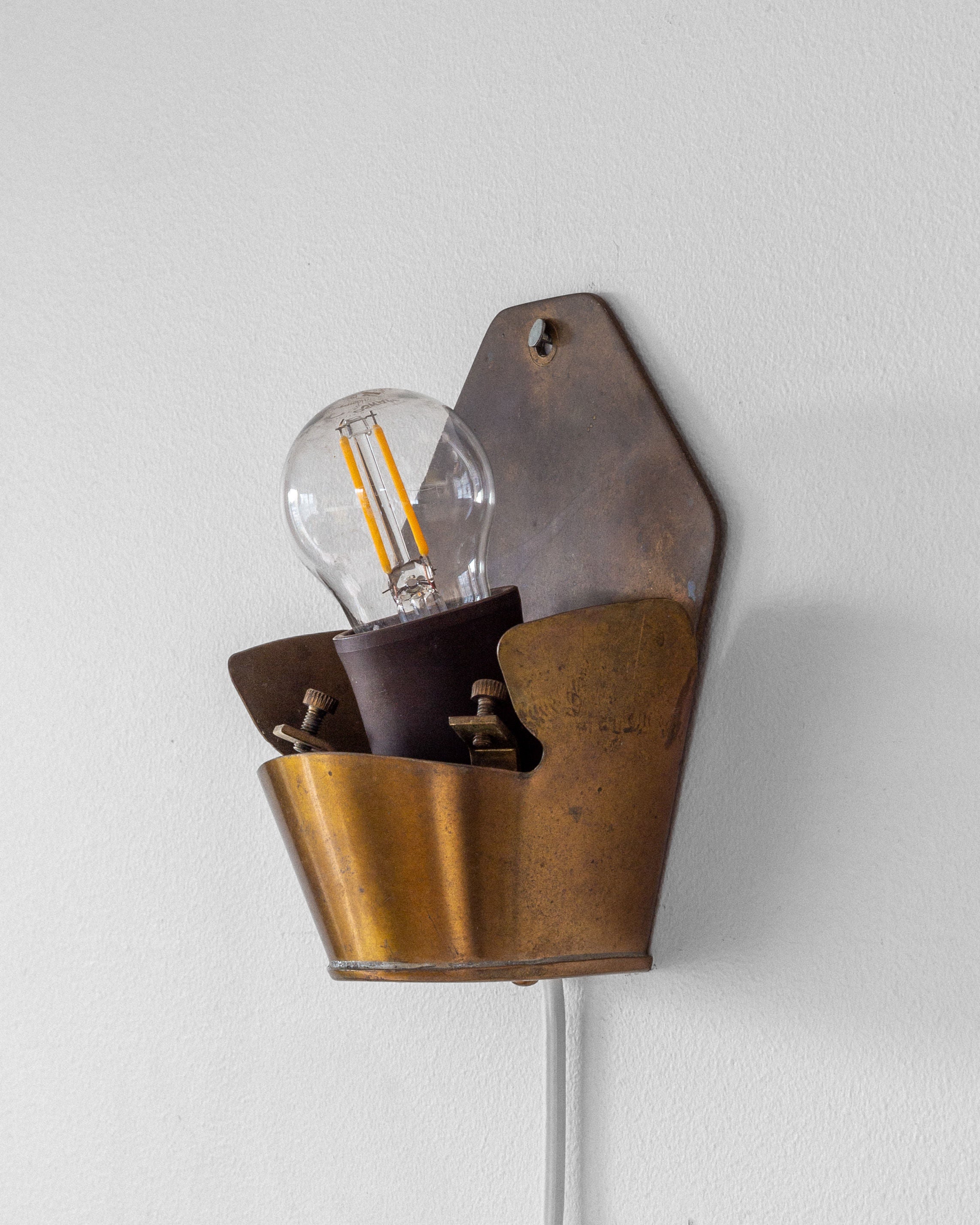 The Spigel Vintage "Coquille" Wall Light from Sweden, 1940s, features a brass fixture with an exposed Edison-style bulb. It's mounted on a plain white wall and connected by a visible white wire.