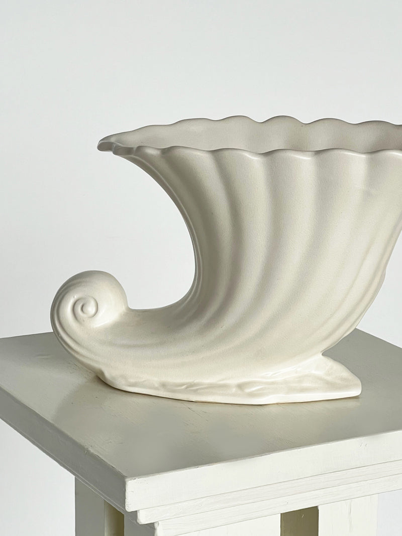 Cream ceramic wave vase profile view showing sculptural curved handle
