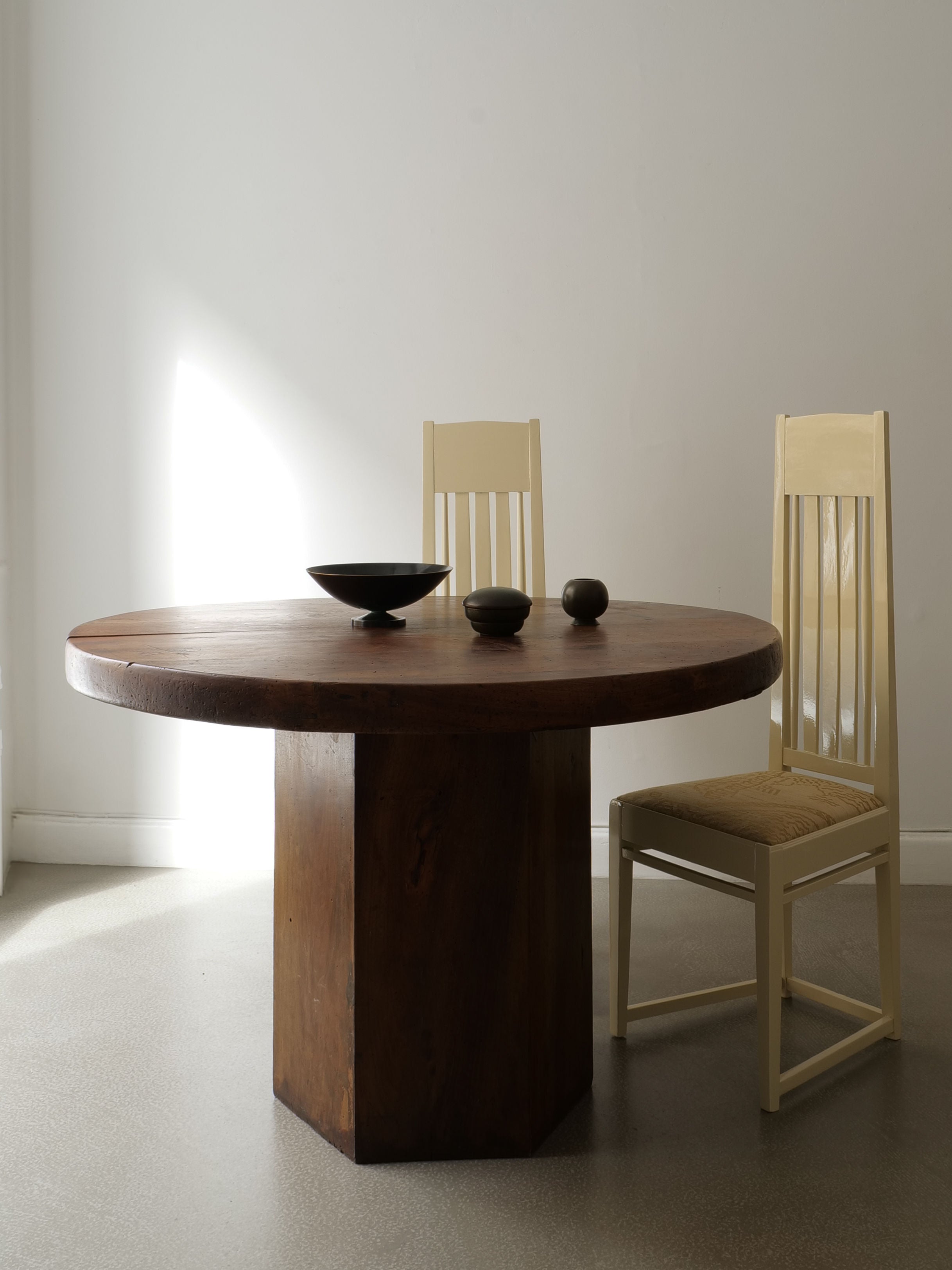 Round walnut dining table with bronze jars lifestyle setting