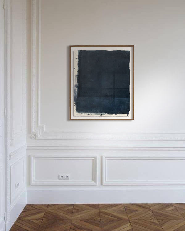 Abstract dark blue pigment painting in wooden frame on white paneled wall