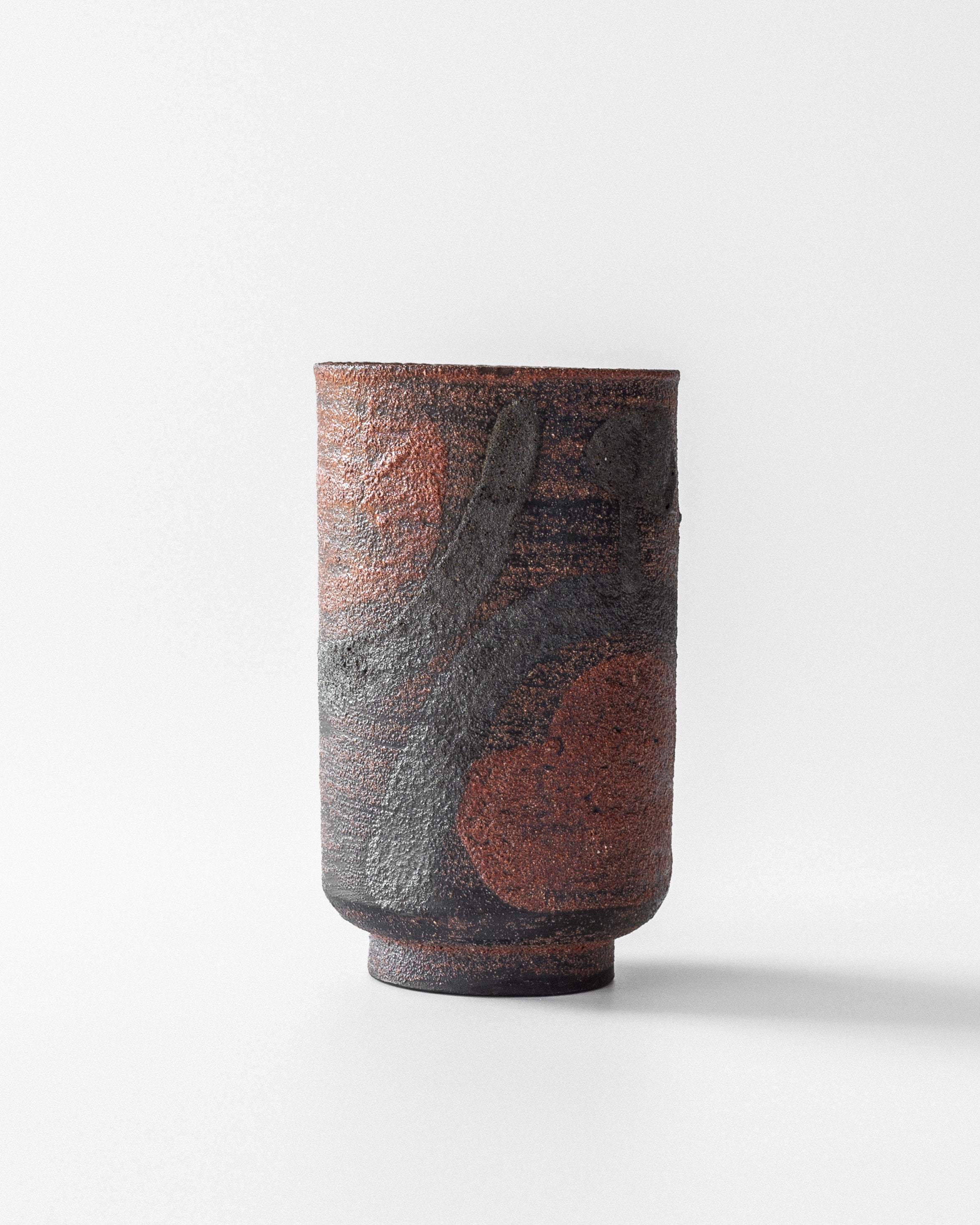 A Modernist Vase by Jaap Dommisse for Spigel, with a textured cylindrical design and a reddish-brown and dark gray abstract pattern, is set against a plain white background.