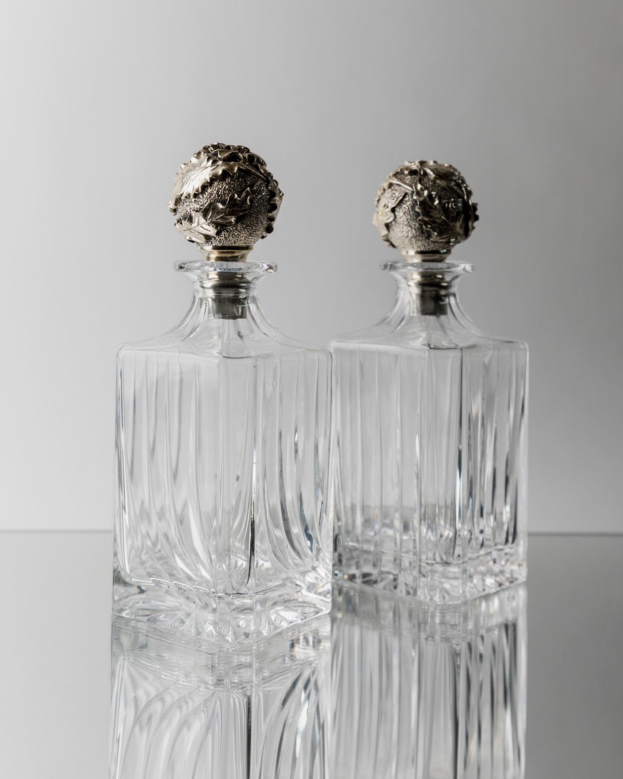 Pair of vintage crystal decanters with ornate silver stoppers 1950s