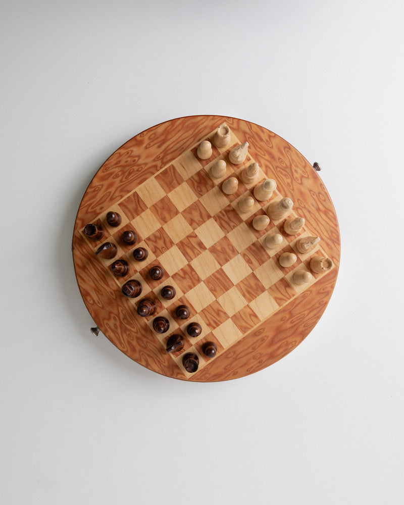 The Bottega Jacobs Mid Century Design Chessboard from Italy, 1960s features a circular board with a light and dark wood pattern and hand-carved wooden pieces arranged for the start of a game, exuding vintage elegance.