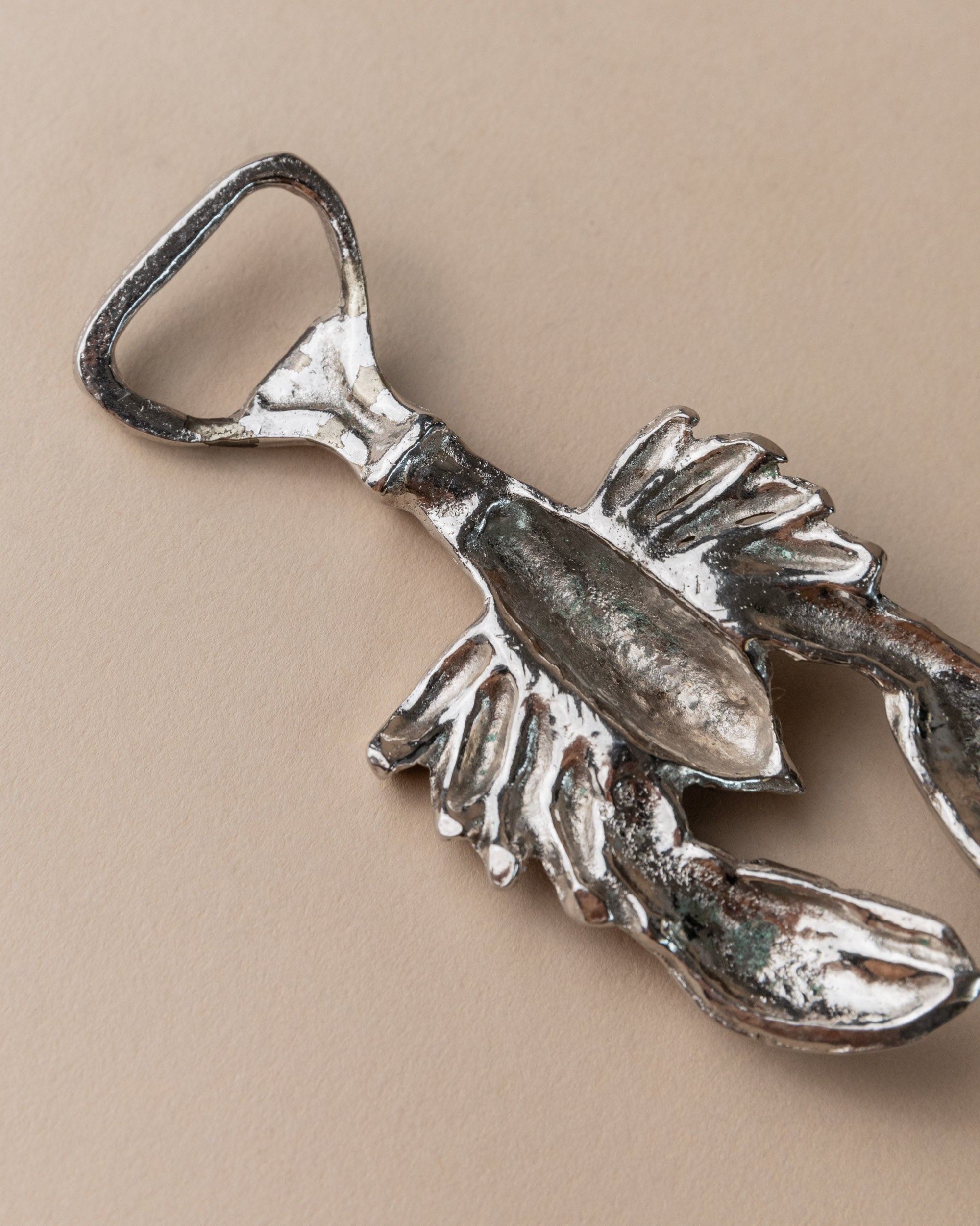 Silver plated lobster bottle opener detail showing weathered patina