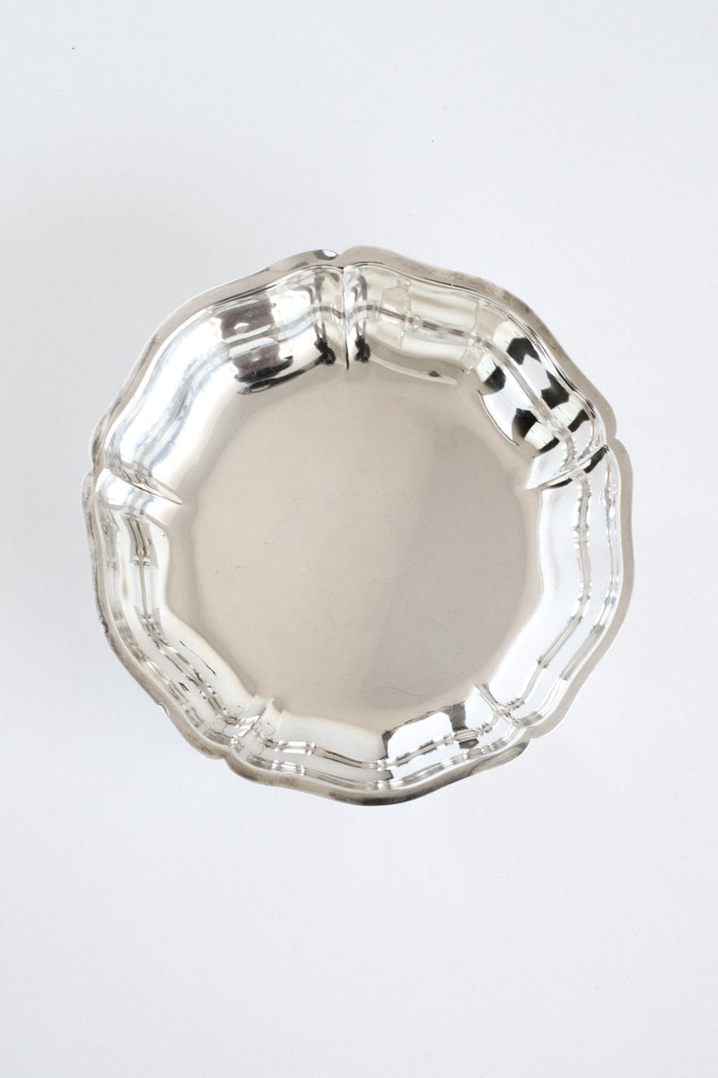 The Silver-plated Bowl by septembre studios features a shiny, round design with a scalloped edge, shown from above on a plain white background.