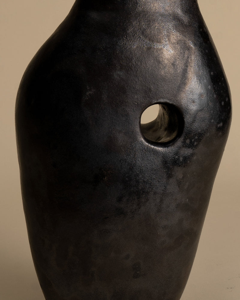 Black ceramic vase with circular opening, tunnel design detail