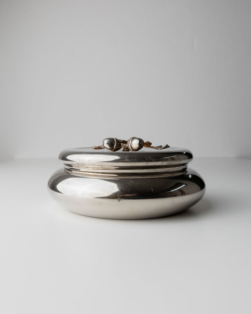 A Silver-plated Box from 1950s Italy by Bottega Jacobs sits on a white background, featuring a smooth, shiny surface with a metallic acorn handle topped by two pearl-like accents.