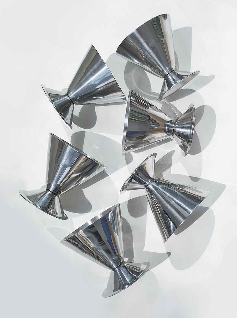 Set of six polished chrome conical cups arranged in artistic display